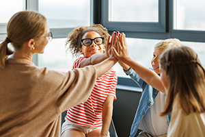 group of elementary children doing a high Five