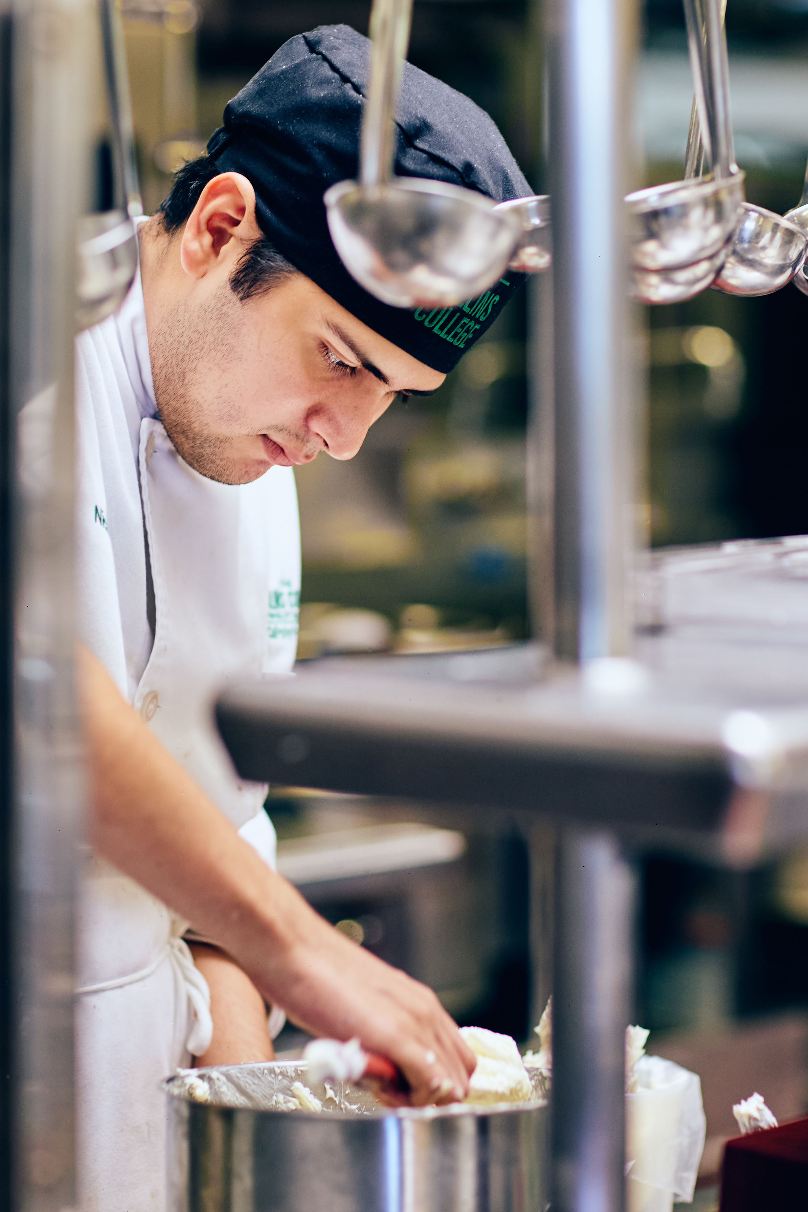 Student cooking over a pot in the kitchen.
