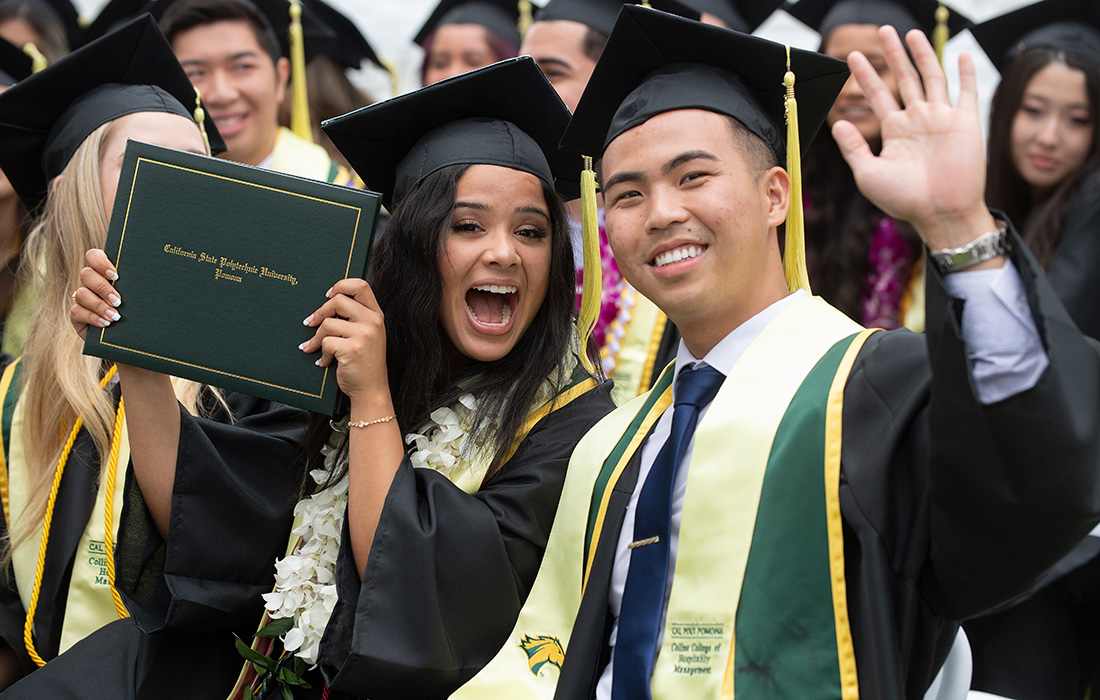 A male and female graduate smile for the camera during the 2023 commencement ceremonies.