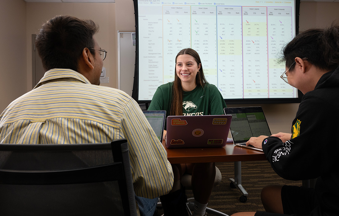 Advisor speaks to students in an office.