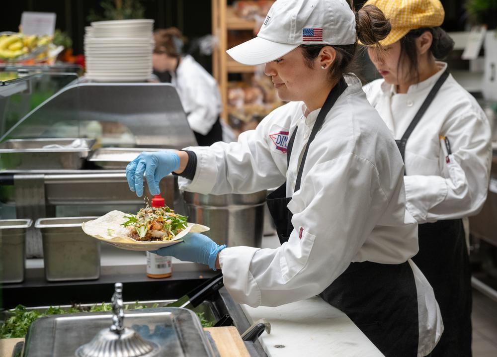 Lexi Segovia assembles a wrap at a kitchen station.