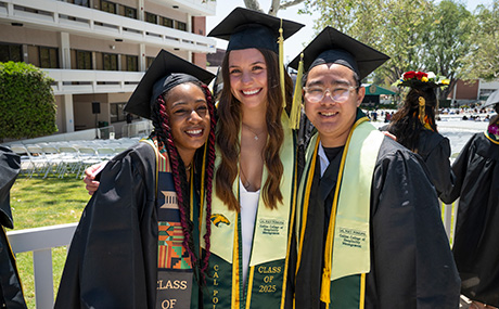 Three collins college graduates smile during commencement. 