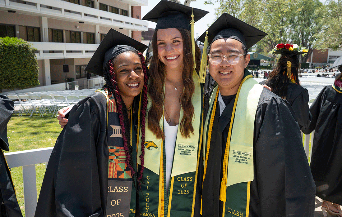 Three 2025 Collins College grads smile during commencement.