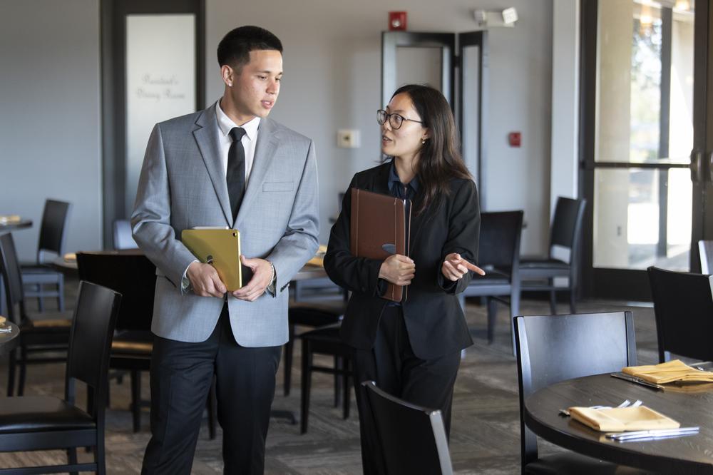 five students posing with arms around each other under the collins college archway