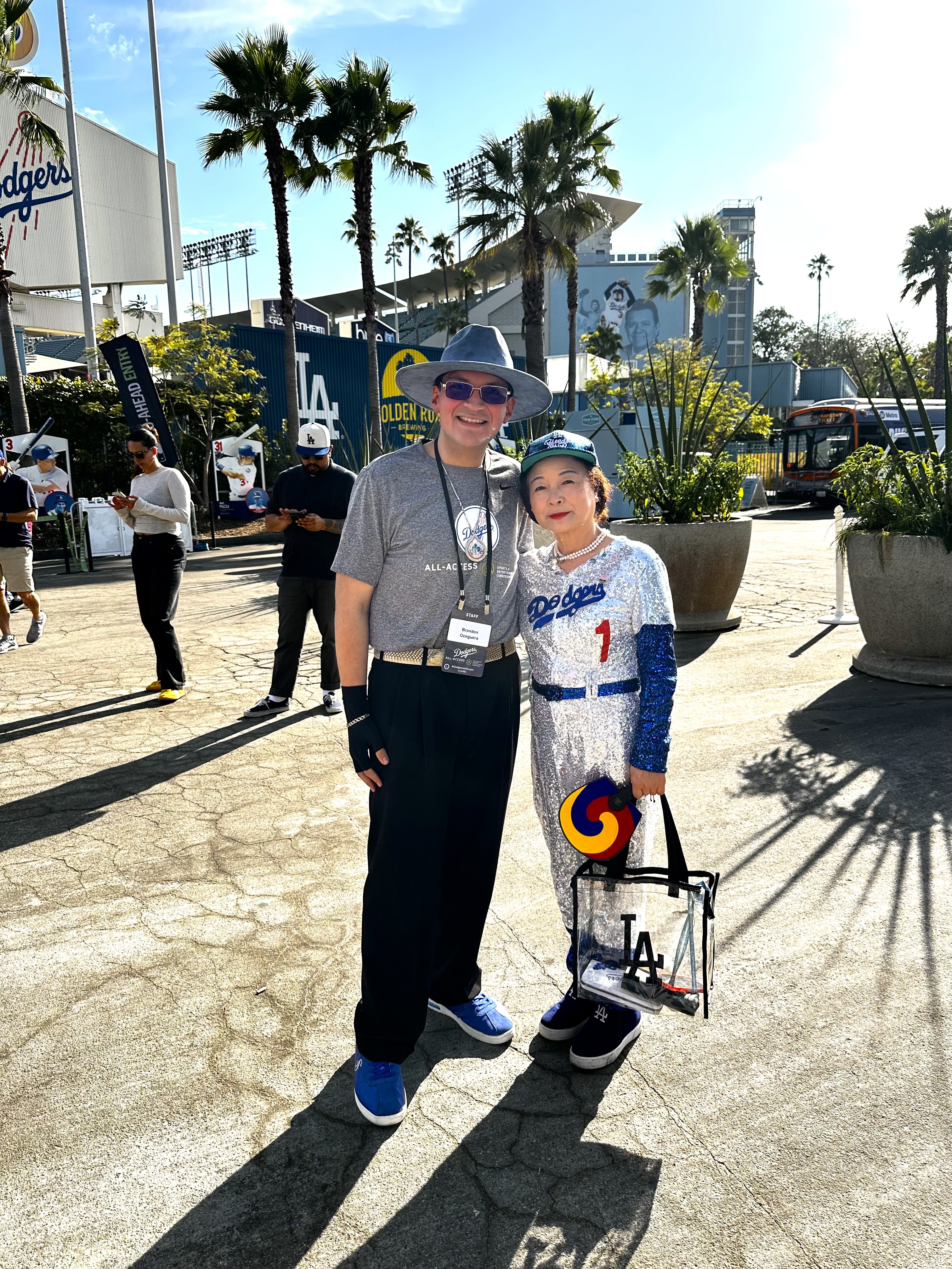 woman in a sparkly dress posing with a student at dodgers all-access event