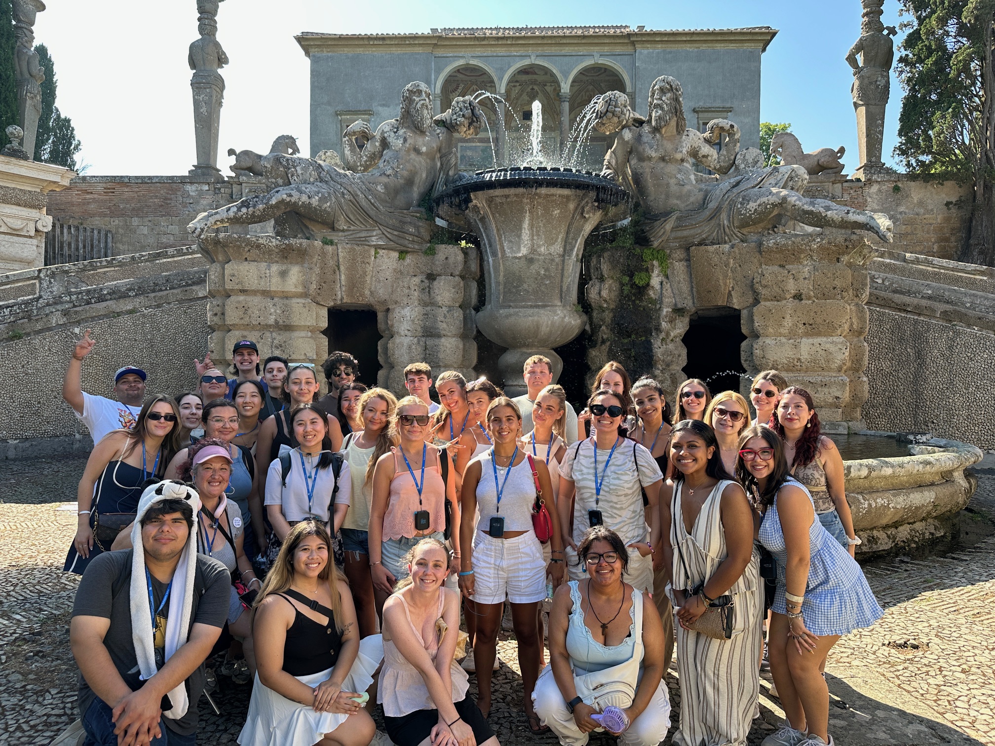 A group of hospitality management students posing outside in Italy for a group photo.