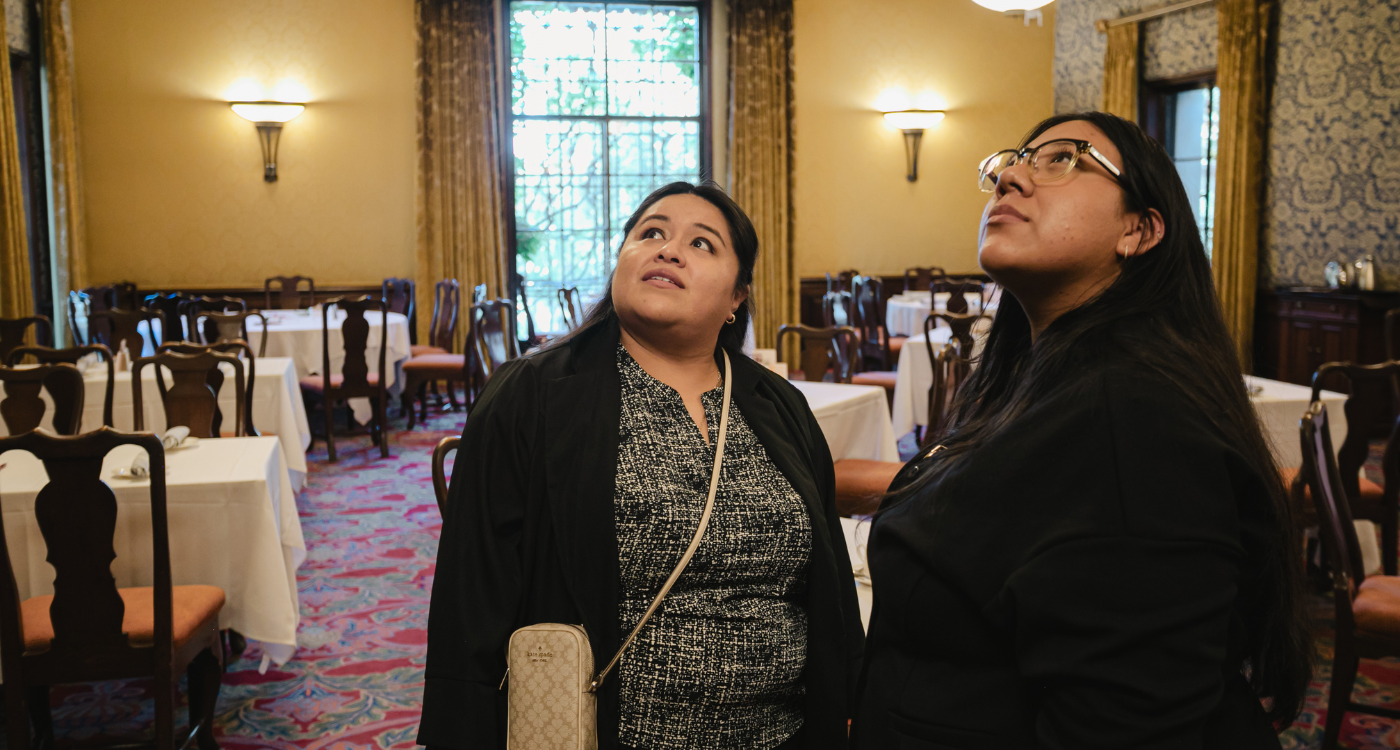 Two students pictured indoors looking upward