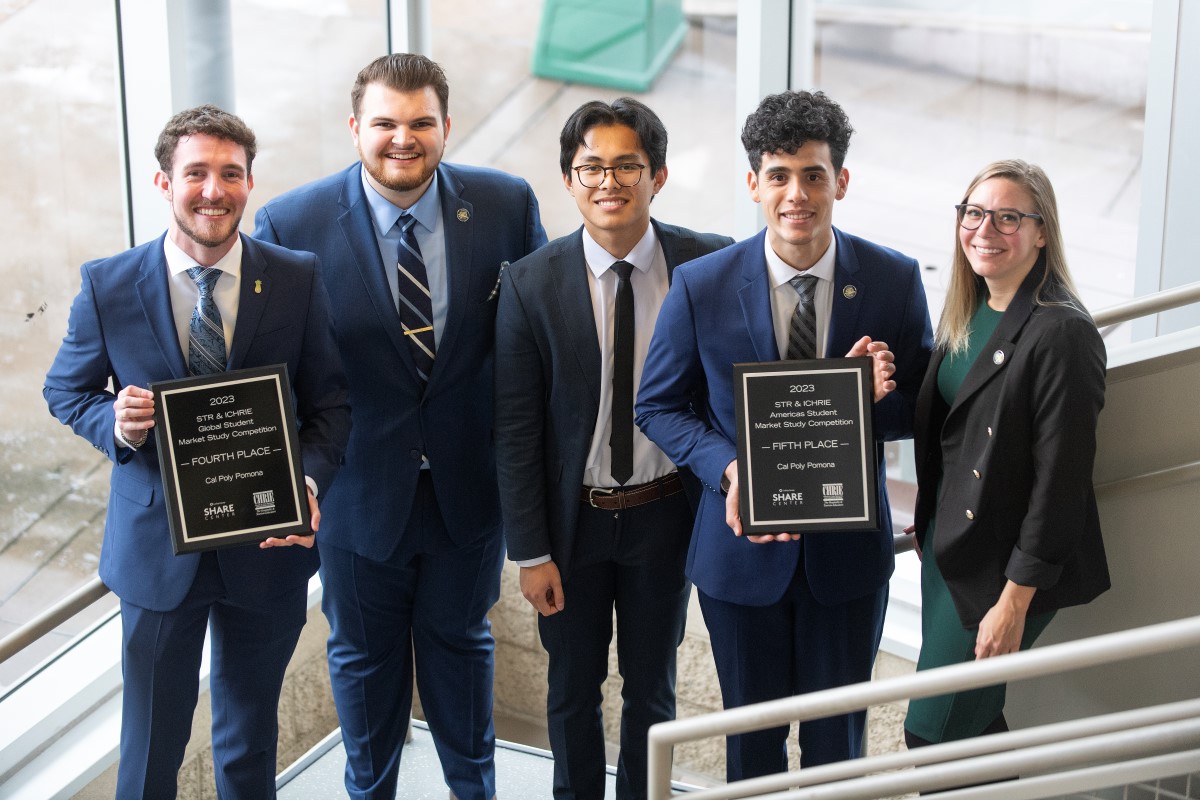 five students show off their competition plaques