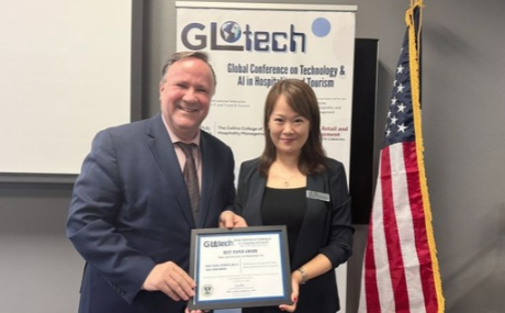 Wan Yang holding best paper award at the GLOTECH conference.