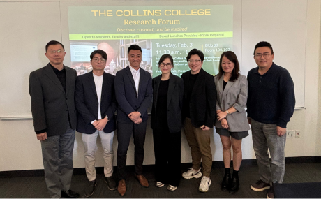 Professors from the forum stand in front of a research slide inside the classroom.