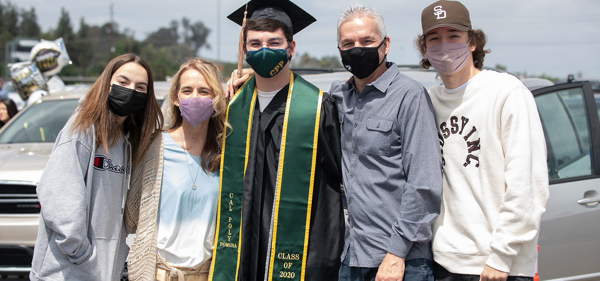 College of Business grad poses for group family photo.