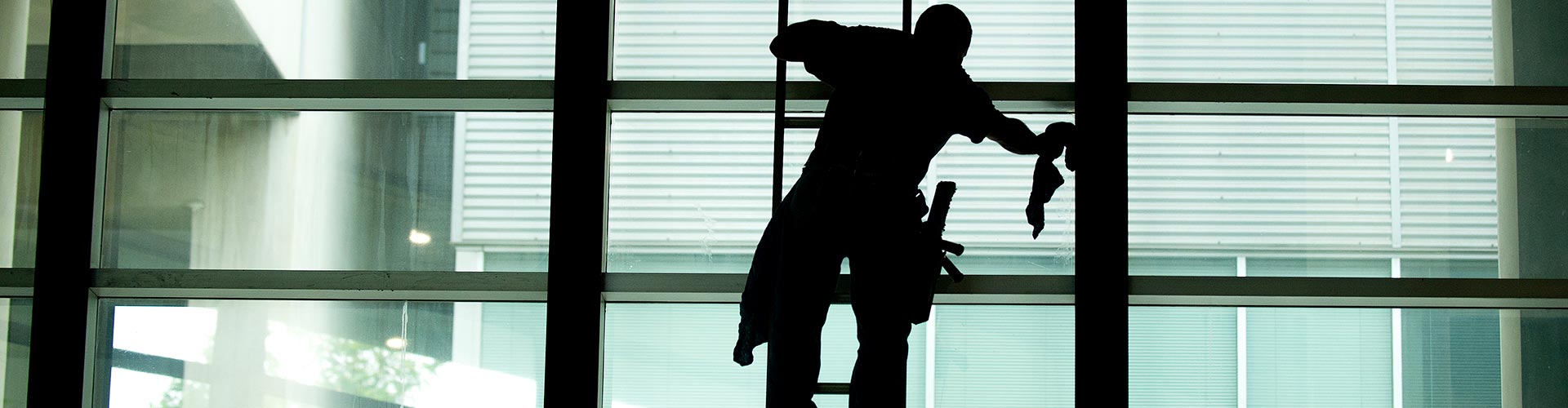 A man washes the windows in the Registrar's Office