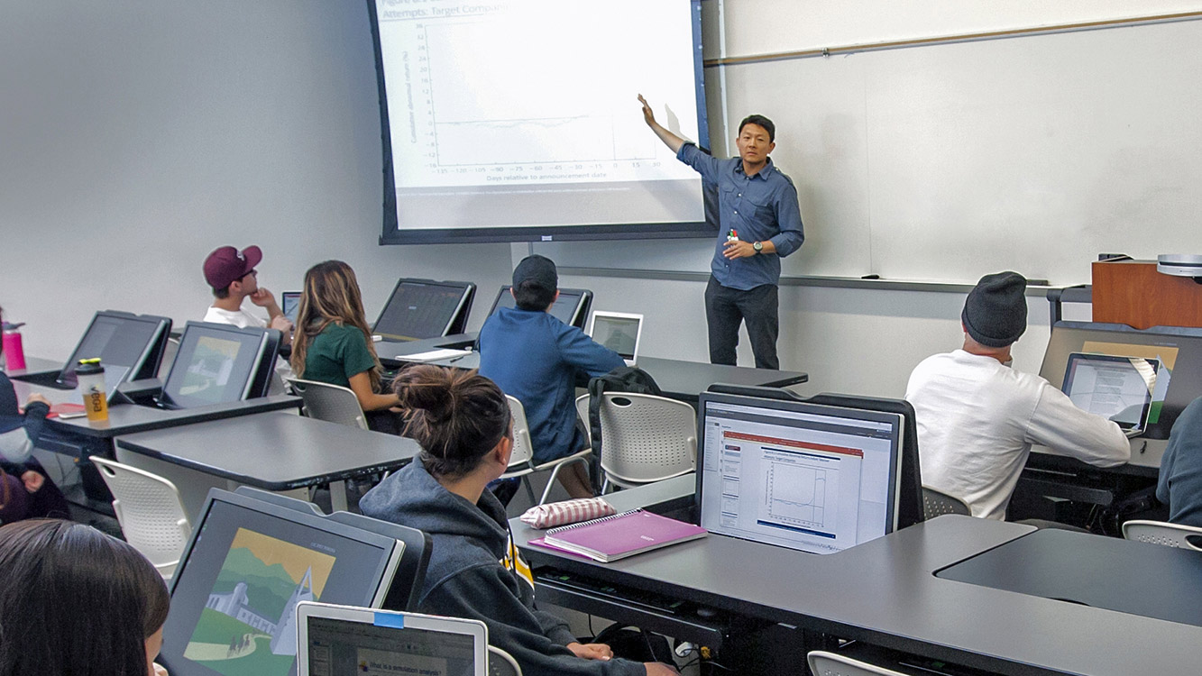 person working at their desk in front of two screens