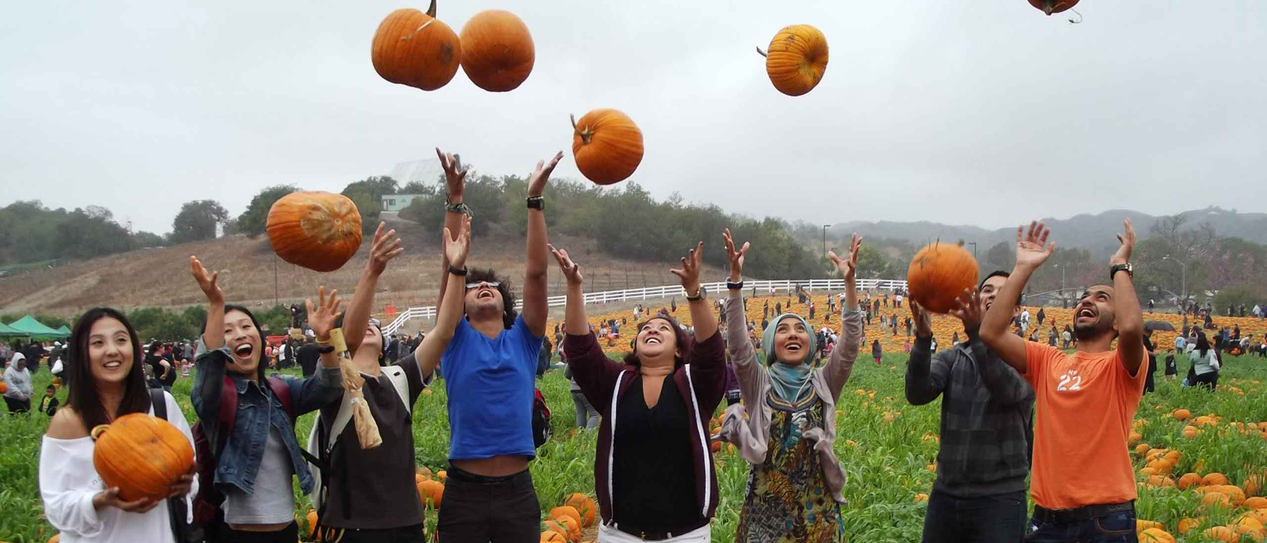 student throwing pumpkin in air