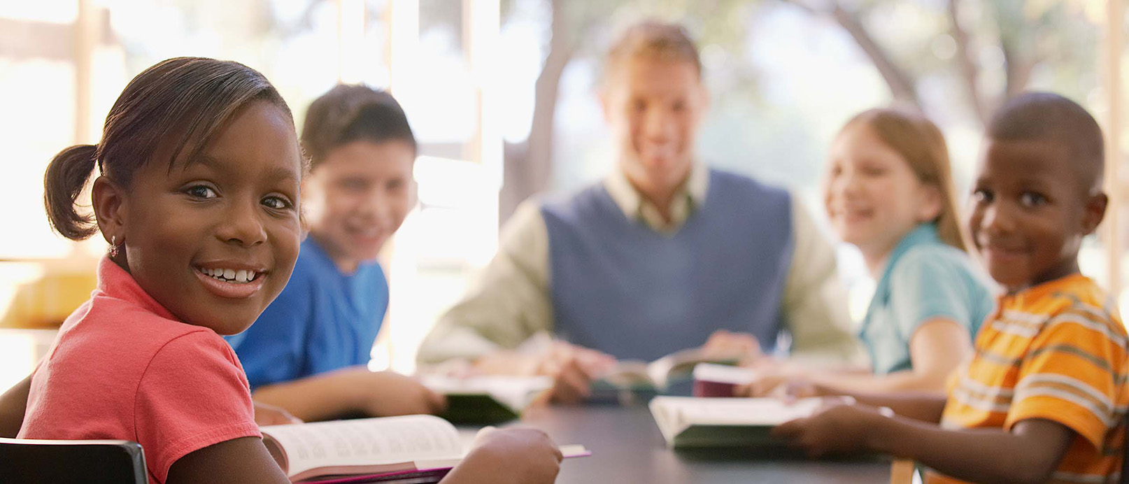 kids sitting at a table with a teacher