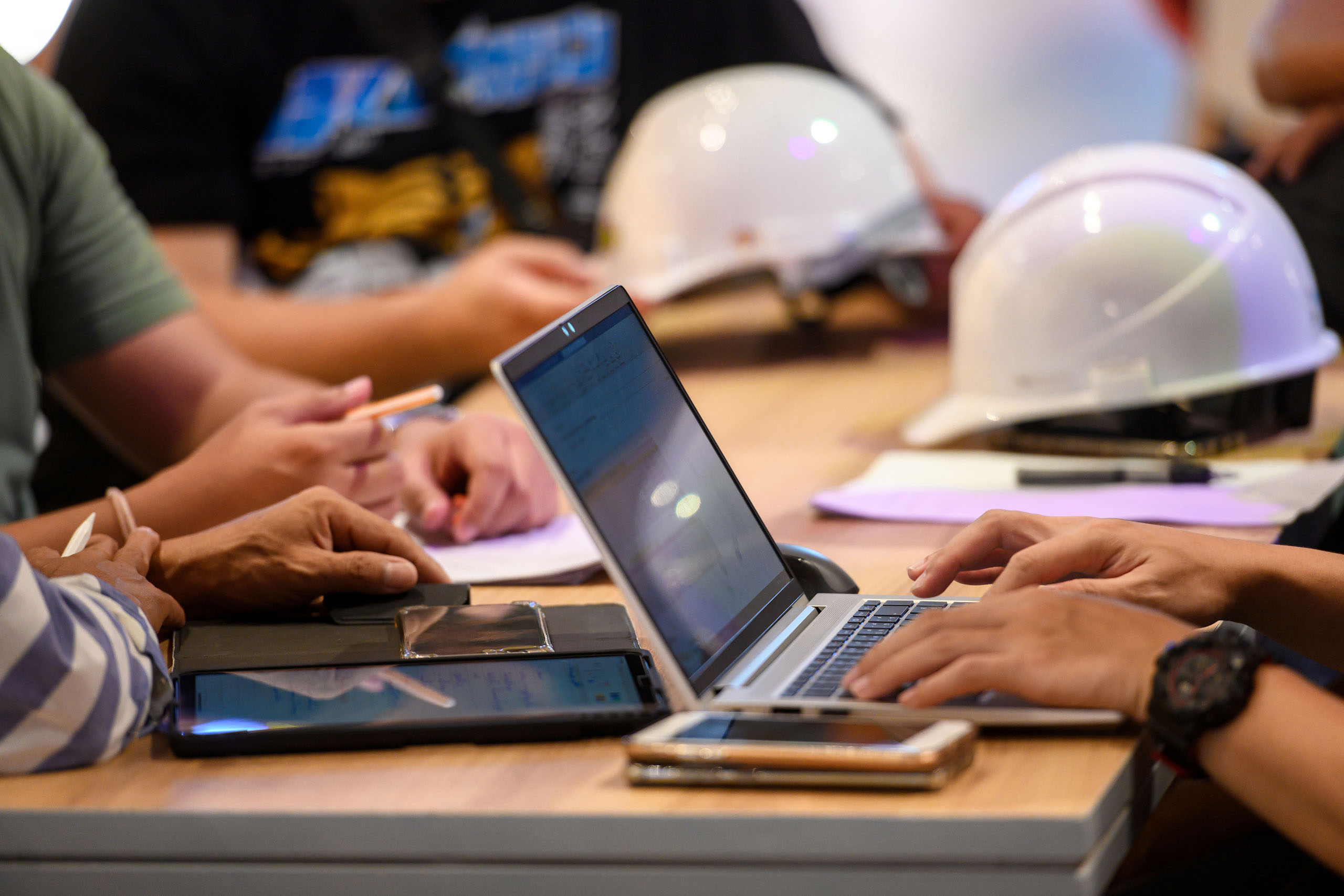 construction hardhats next to laptop