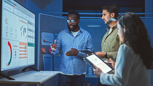 three people standing in front of a screen