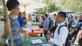 administrator talking to student at tabling event