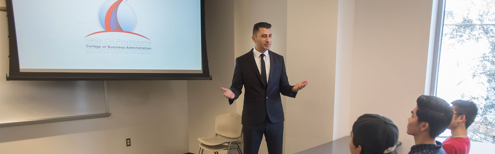 Professor Ozkaya speaking to students in a classroom in the CBA building.