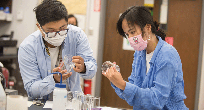 Two students work together in a chemistry lab. 