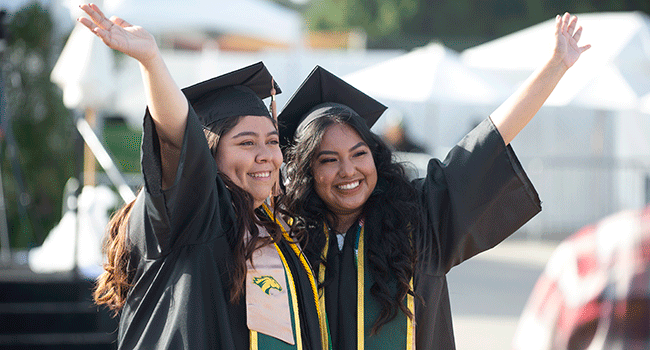 Two College of Business Graduates celebrate during the 2020 Commenecement ceremonies
