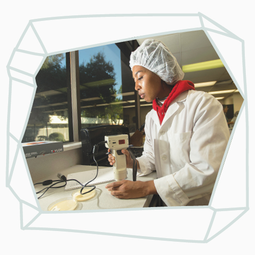 A female student in the kitchen measuring ingredients