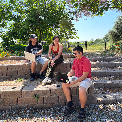 Three students working in the Outdoor Classroom at the Lyle Center for Regenerative Studies