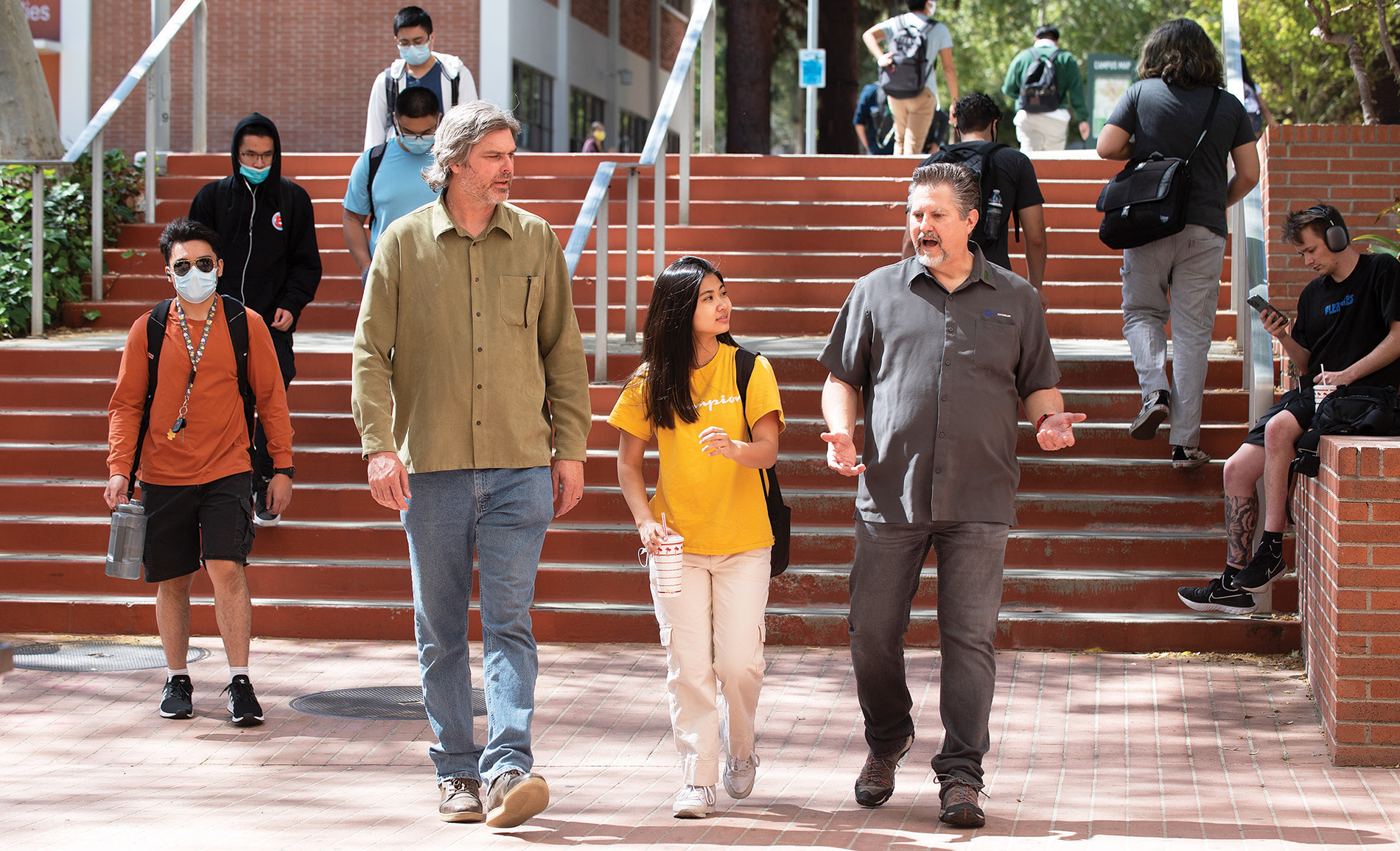 Alumni Elias Wilson, left, and Eric Schmidt talk with student Maggie Hoang