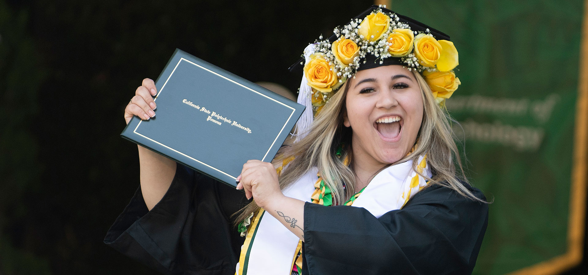 CLASS Graduate smiles holding her diploma