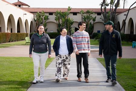 Michael Miser walking on campus with three other people