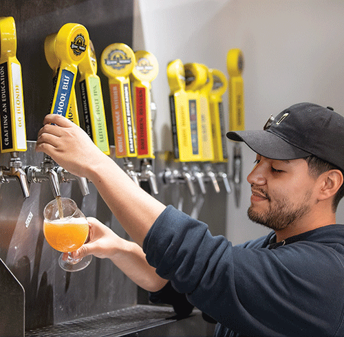 Louie Vinegas pours a beer at Innovation BrewWorks