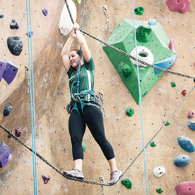 A female student rock climbs at the BRIC
