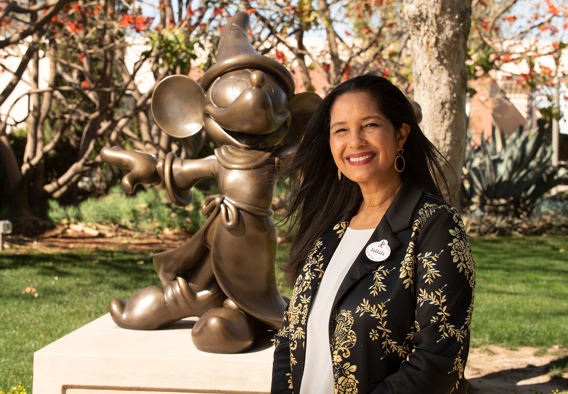 Barbara Bouza poses with a Sorcerer Mickey statue at Team Disney Anaheim.