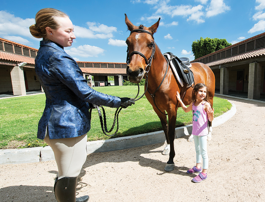 a kid meeting one of the horses and trainer after the show