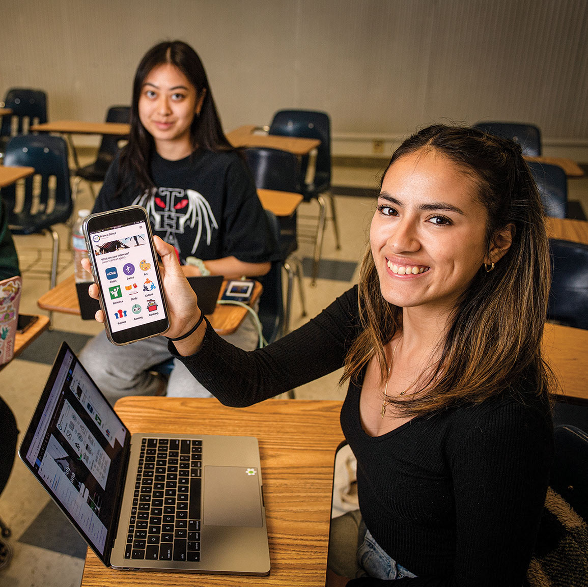 Two female students holding mobile phones 