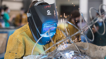 A student welding the Rose Float