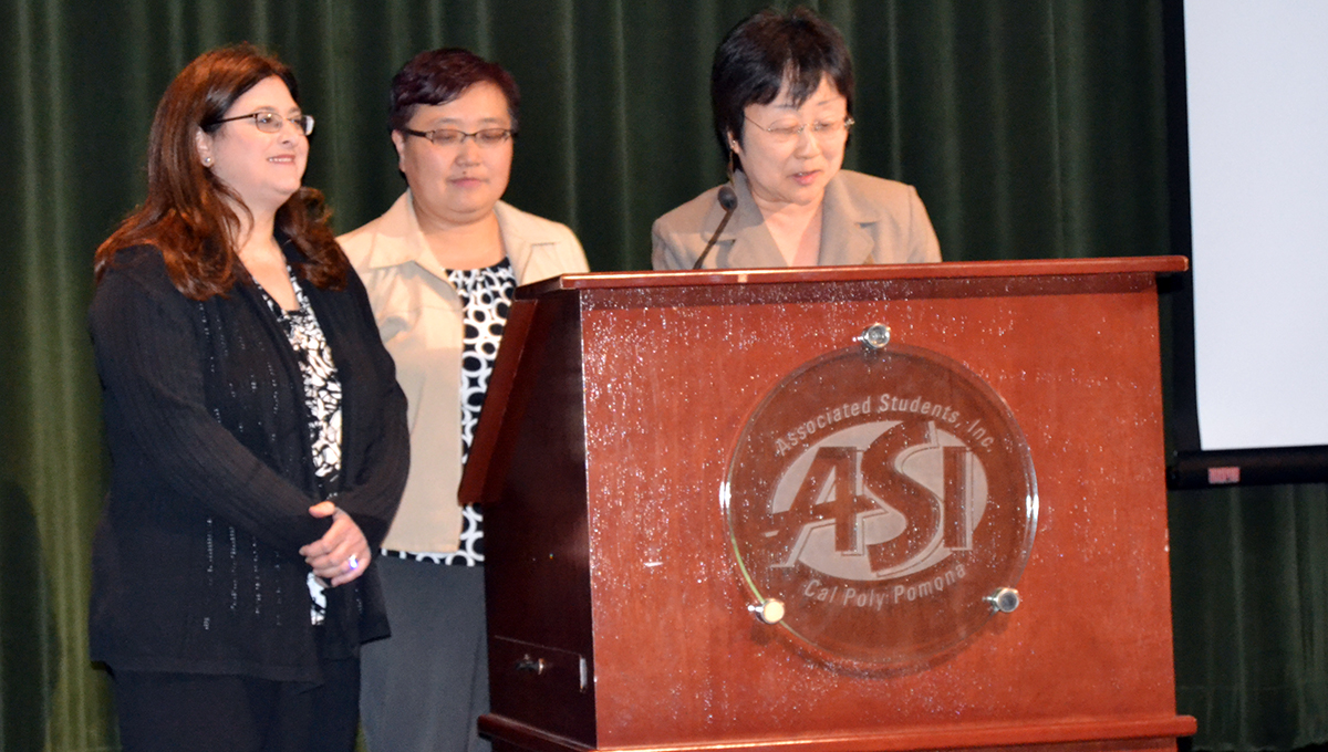 Awardee on stage awaiting to receive her award