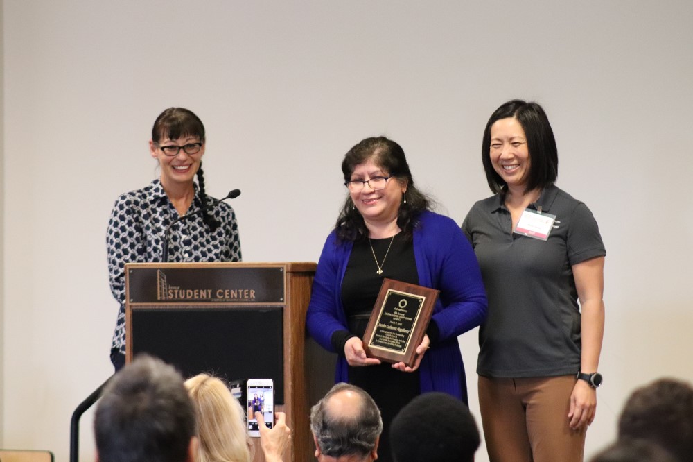 Group of faculty handing award to staff