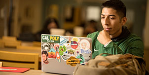 student studying on his laptop in the university library