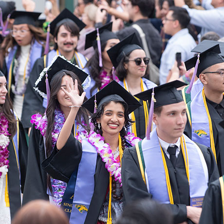 College of Environmental Design graduate waving hand at commencement