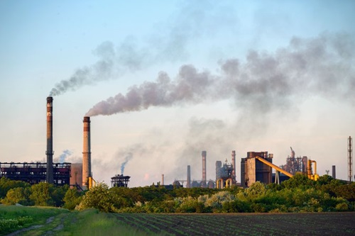 factory releasing smoke into atmosphere