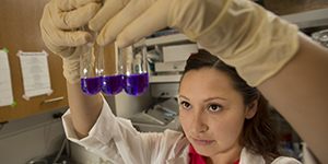 Student holding up test tubes with blue liquid in them