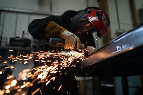 Person welding metal with active power tool 