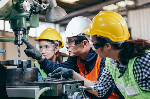 students observing instructor operate machinery