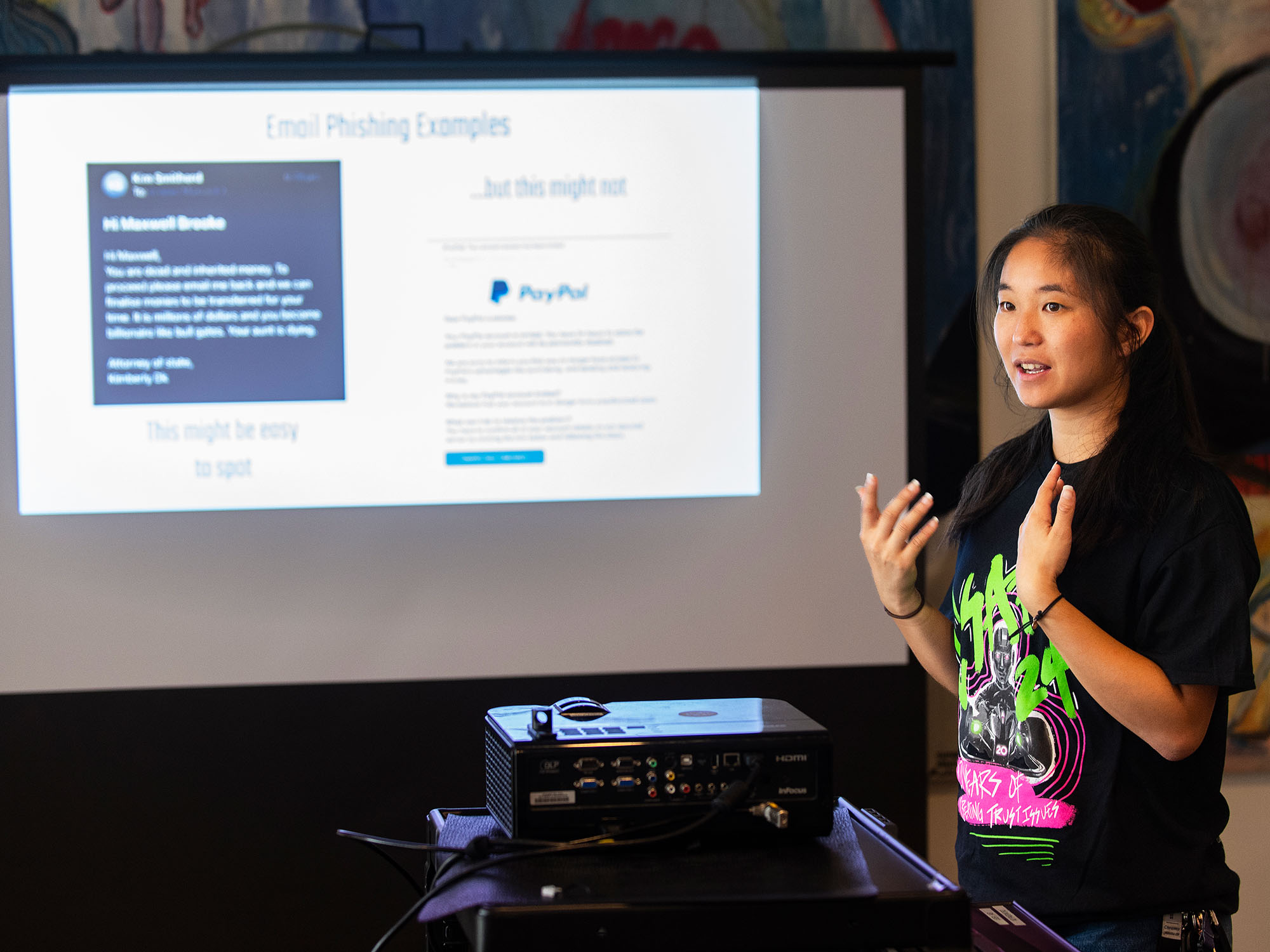 A women speaks in front of a projection screen