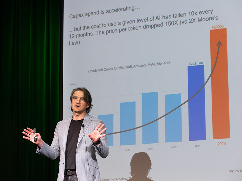a man presents in front of a projected screen