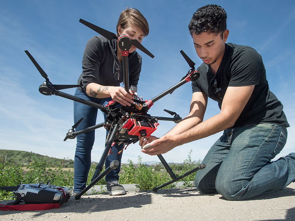 two students work on a drone