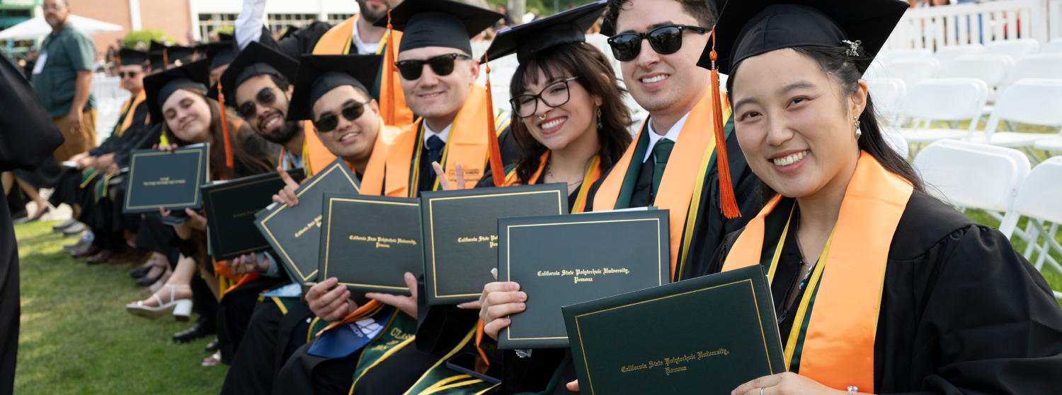 Students pose with degrees at Commencement