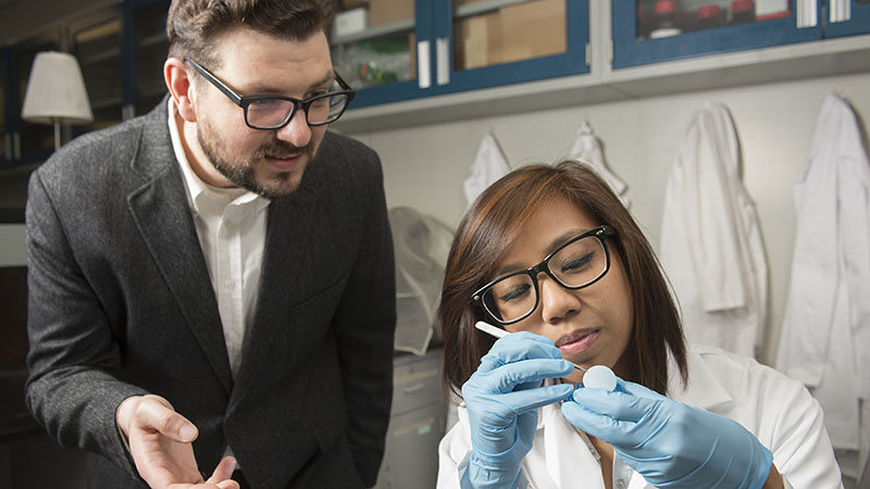 A professor teaching a student in a lab.