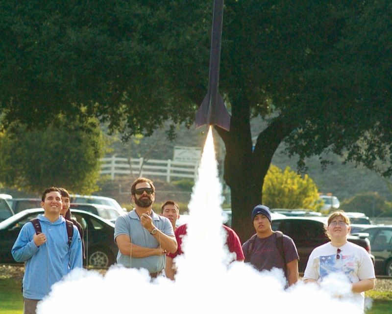 Don Edberg and students watching a rocket take flight.